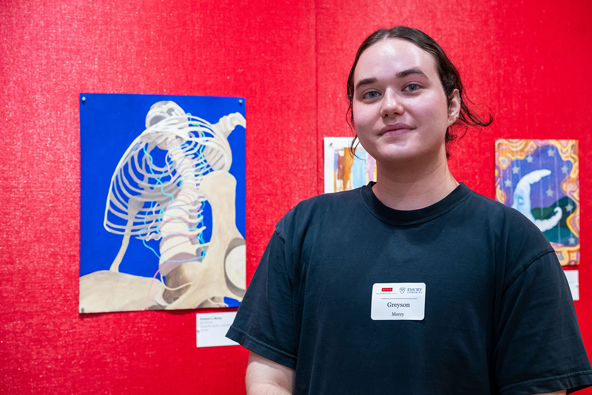 Greyson stands with his artwork