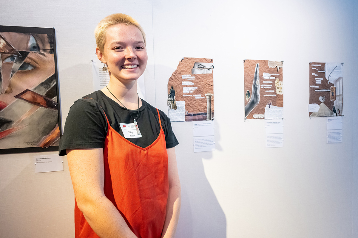 Paige stands in front of her collages