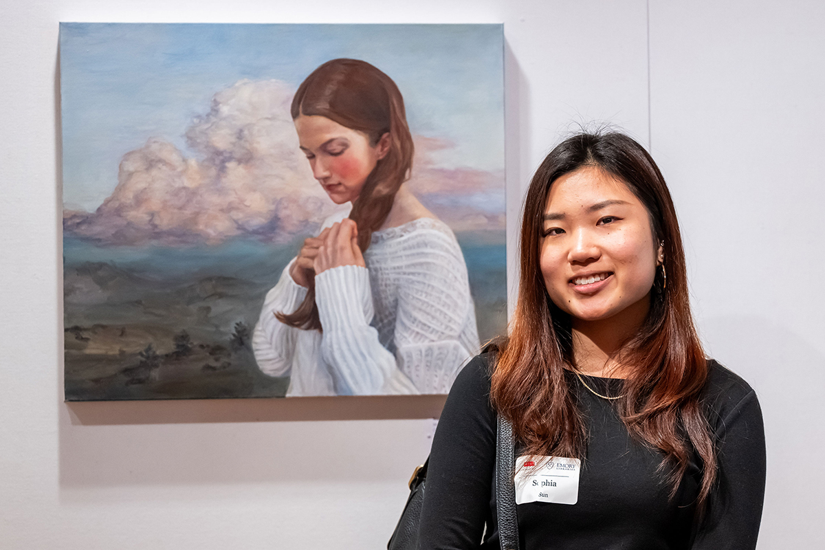 Sophia stands with her art