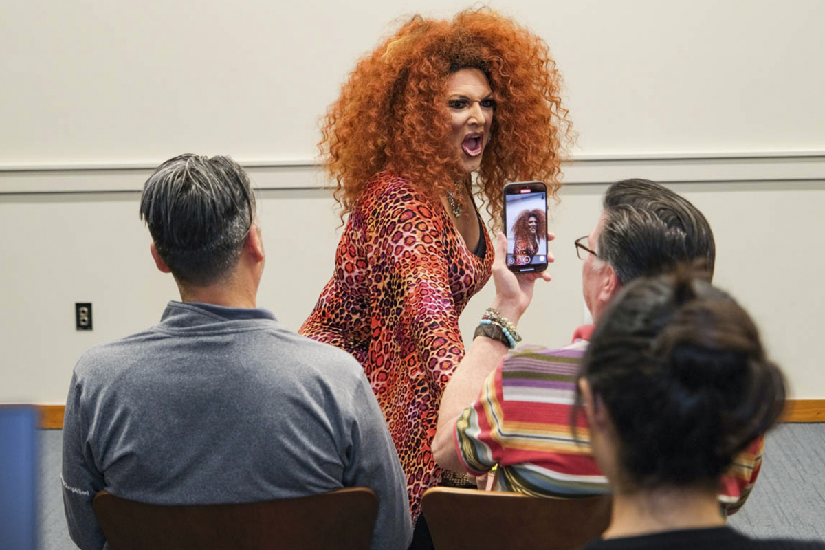 performer wearing red wig posing for photo