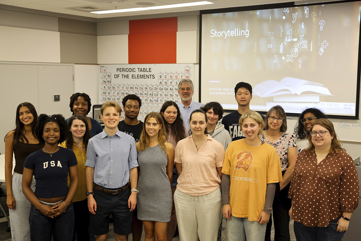 group of college students standing in a classroom smiling