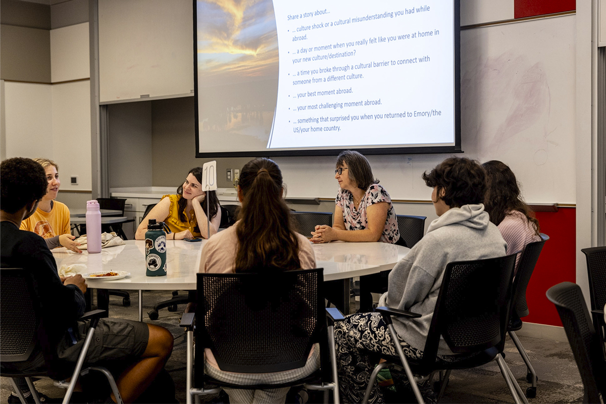 college students and an adult sitting around a table talking