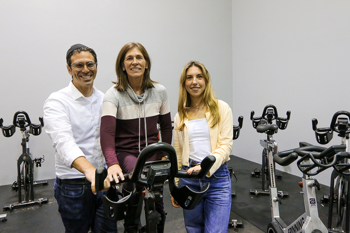 Ira Bedzow, April Flint and Julia Jarvis standing in a spin classroom