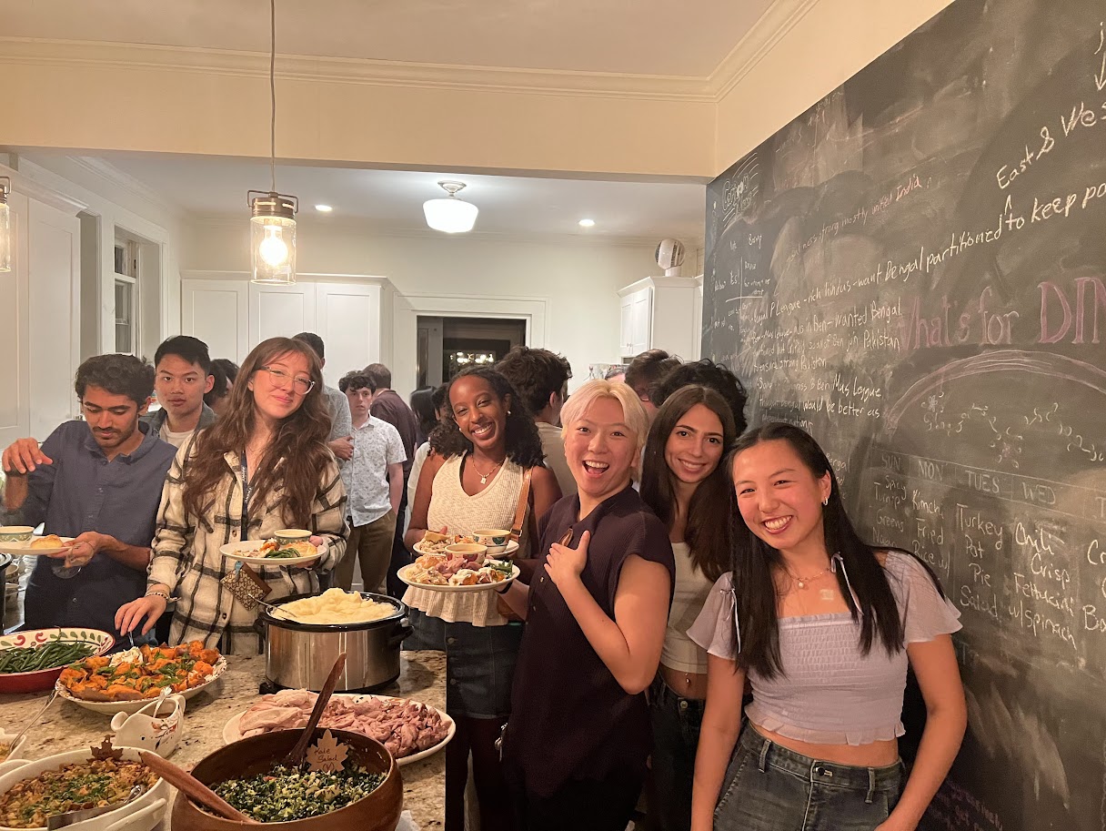 students gathered in kitchen with Thanksgiving plates
