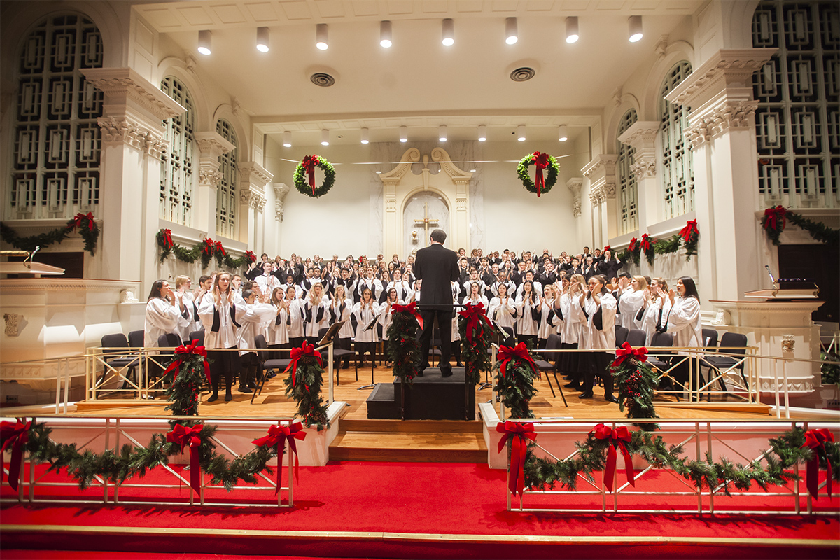 choir singing with holiday decorations surrounding them