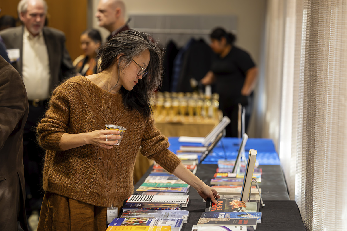woman reaching for a book on a table