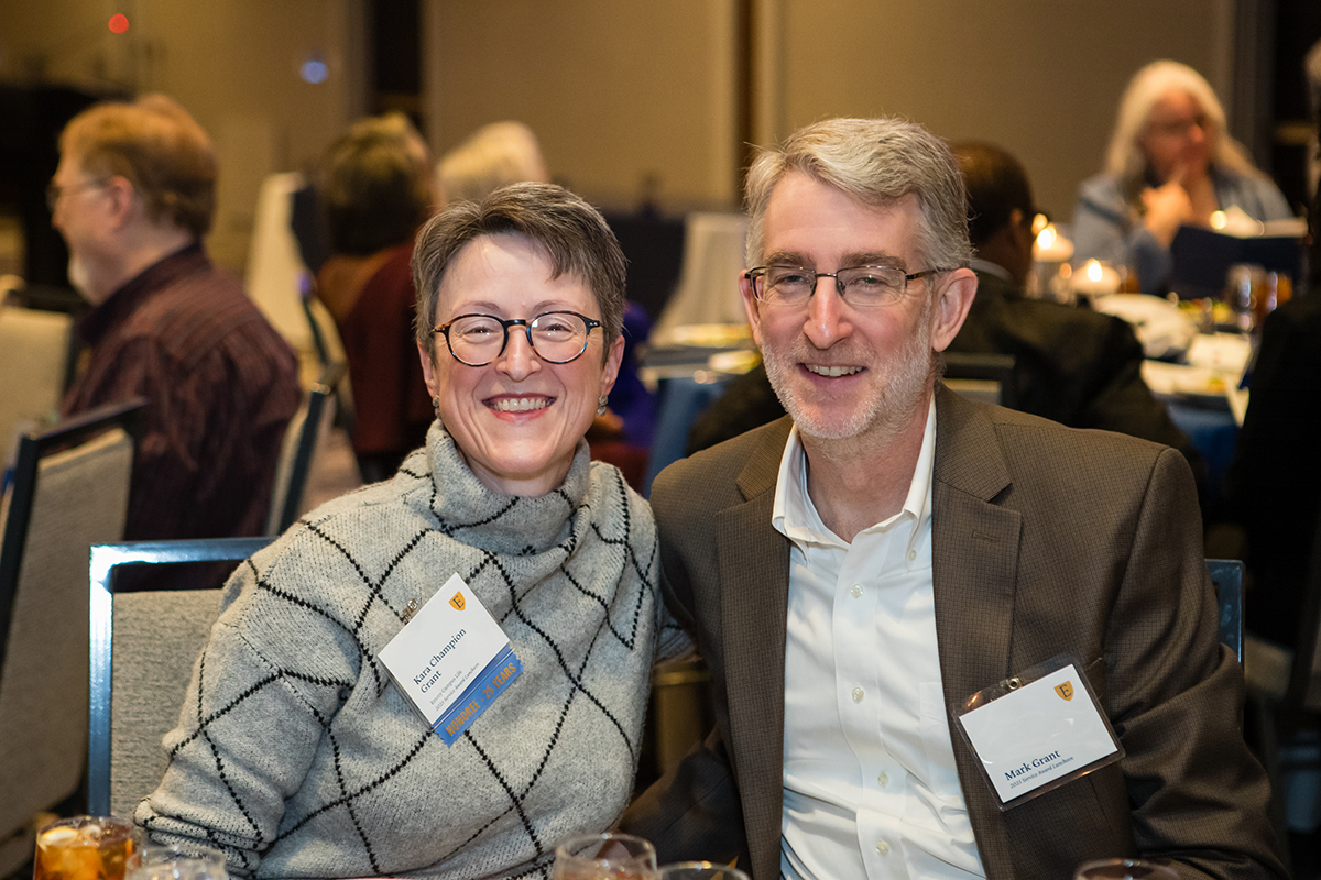 A married couple smiling at their table