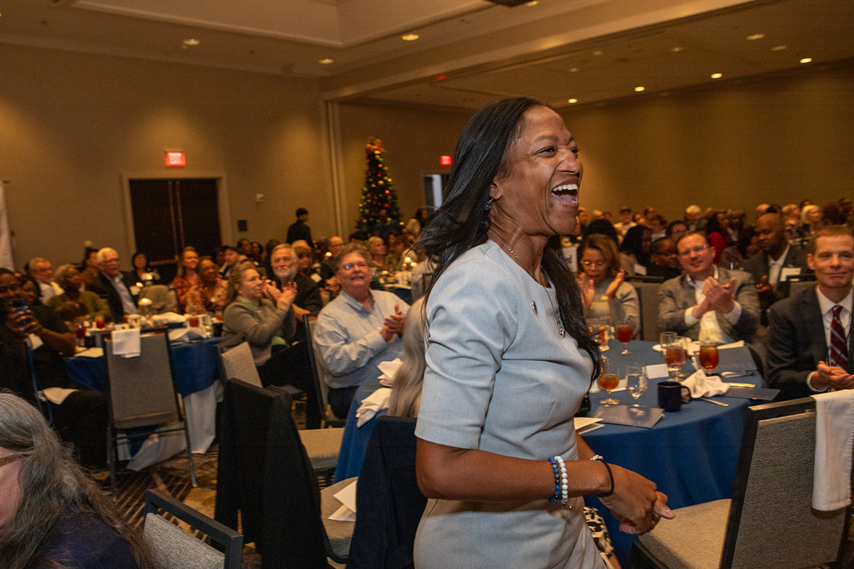 woman being honored laughs and walks onto stage