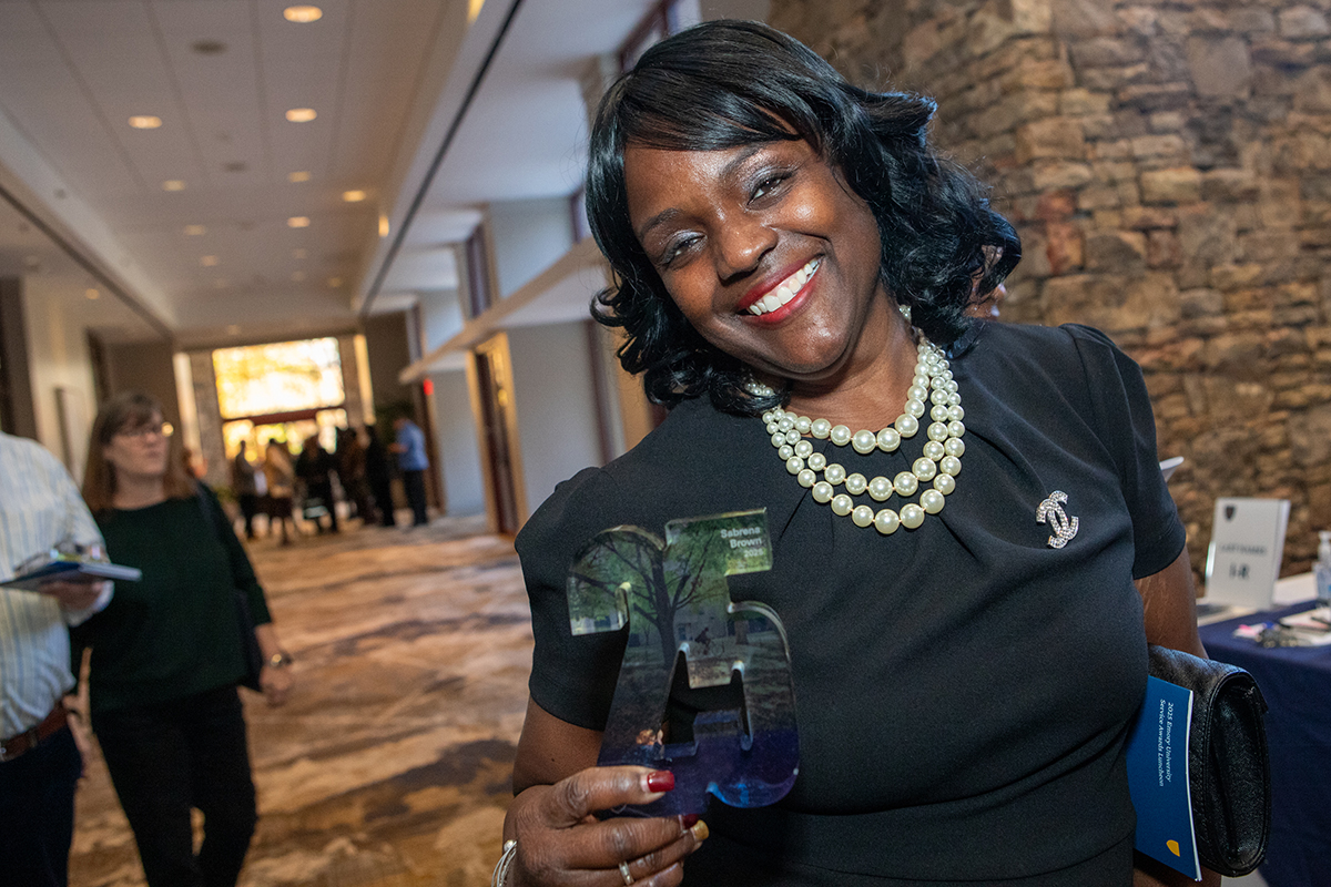 woman poses with 25 year award