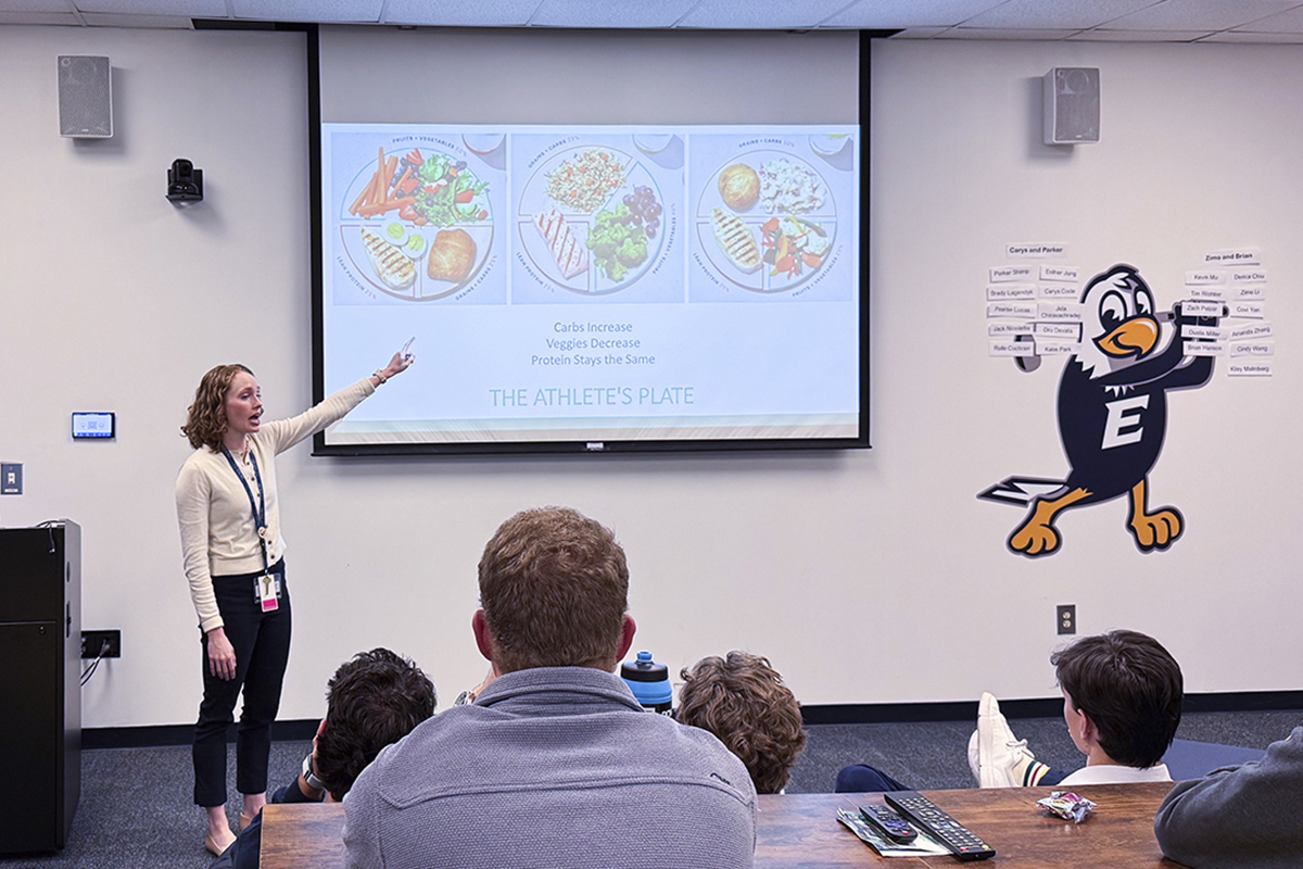 A woman standing in front of a powerpoint presentation