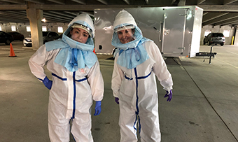 Two employees wear full PPE