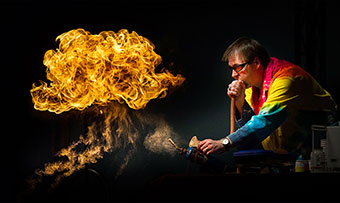 An Emory professor in a tie-dye labcoat conducts an experiment that results in a dramatic fireball.