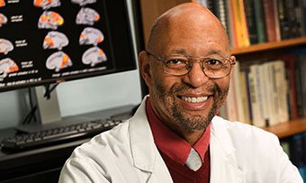 Anthony Stringer, a professor in Emory's Department of Rehabilitation Medicine and director of the Division of Neuropsychology and Behavioral Health, poses for a photo in front of a computer screen