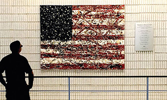 An individual looks at a painting of the American flag