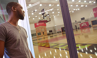 An athlete stares into the practice basketball court at the Emory Sports Medicine Complex