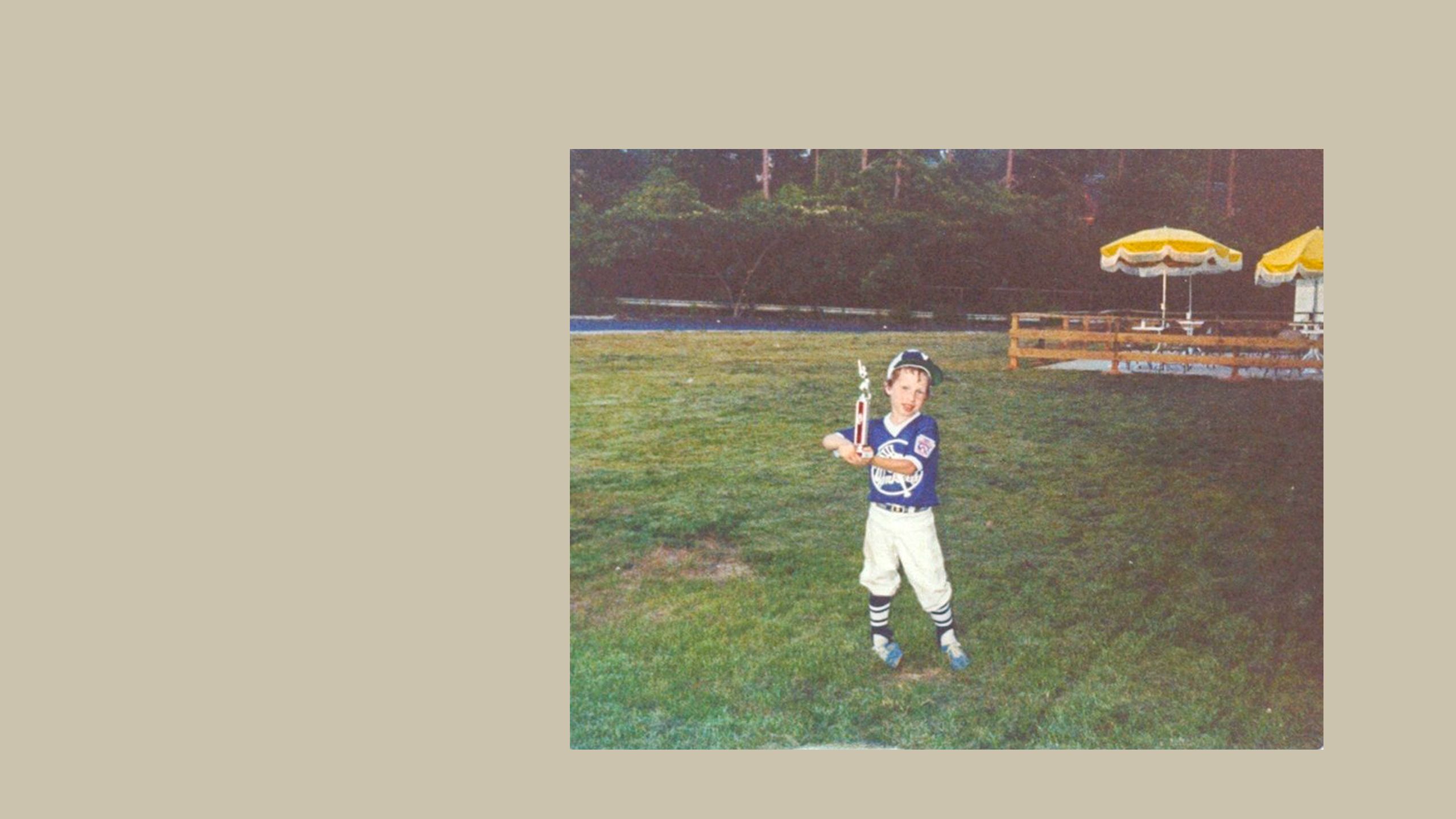 Andy Lipman as a small boy holding a baseball bat in a sports uniform.